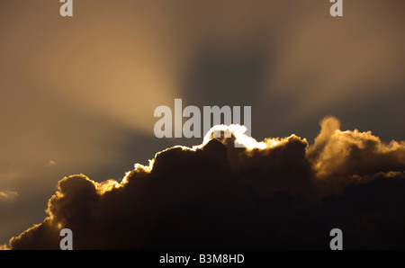 Les rayons lumineux d'un soleil couchant éclatent d'un nuage de tempête Banque D'Images