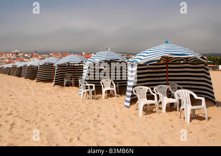 Une rangée de tentes de plage à rayures ligne les sables de plage de Figueira da Foz, Portugal, Banque D'Images