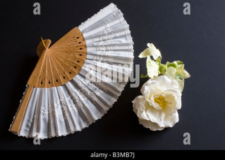 Pliage blanc oriental fan sur un fond noir avec fleur Banque D'Images