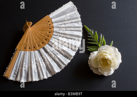 Pliage blanc oriental fan sur un fond noir avec fleur Banque D'Images