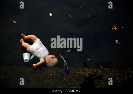 Poupée pour enfants jetés dans l'eau d'ordures Banque D'Images