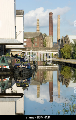 Usine chinmeys se reflètent dans le canal Leeds-Liverpool à Shipley, Bradford, West Yorkshire, Royaume-Uni Banque D'Images