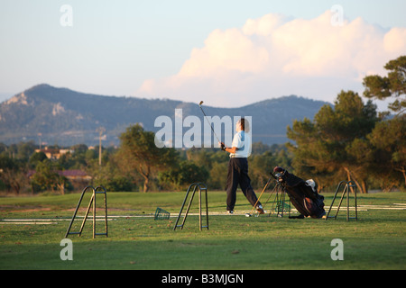 La pratique de l'homme sur un practice de golf - Suivre la boule terre Banque D'Images