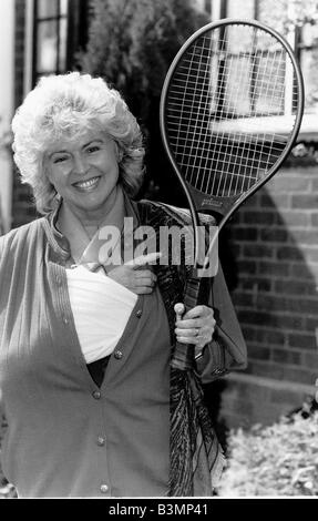 Gloria Hunniford présentatrice TV tenant la raquette de tennis qu'elle était quand elle a battu son useing son bras bras est toujours dans le plâtre Banque D'Images