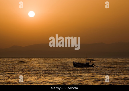 Bateau de pêche de partir de Kitries au coucher du soleil, Péloponnèse, Grèce Banque D'Images