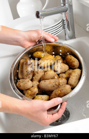 Laver les pommes de terre dans l'HOMME NOUVEAU COLLANDER Banque D'Images