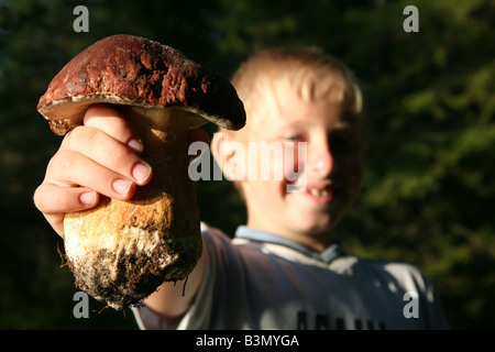 Jeune garçon montrant un énorme cep mushroom (Boletus edulis) sur le lac Onega, en Carélie, Russie Banque D'Images