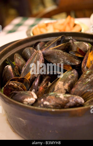 Spécialité locale de 'Moules' Frittes moules et frites dans un restaurant populaire 'Leon' à Bruxelles Belgique Banque D'Images