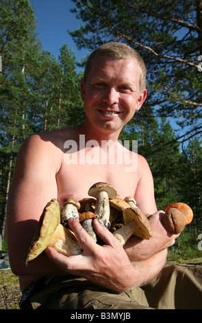 L'homme aux cèpes (Boletus edulis) et red-capped scaber le Leccinum aurantiacum (tiges) sur le lac Onega, en Carélie, Russie Banque D'Images