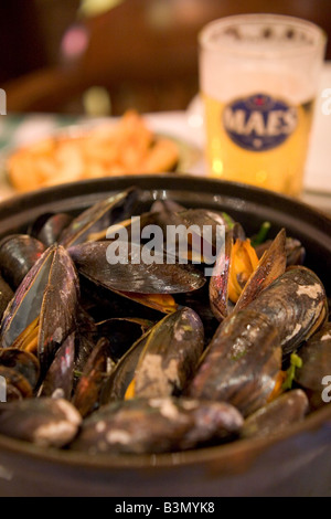 Spécialité locale de 'Moules' Frittes moules et frites dans un restaurant populaire 'Leon' à Bruxelles Belgique Banque D'Images