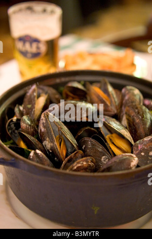 Spécialité locale de 'Moules' Frittes moules et frites dans un restaurant populaire 'Leon' à Bruxelles Belgique Banque D'Images