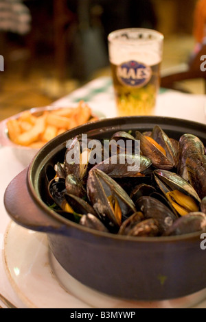 Spécialité locale de 'Moules' Frittes moules et frites dans un restaurant populaire 'Leon' à Bruxelles Belgique Banque D'Images