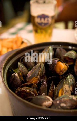 Spécialité locale de 'Moules' Frittes moules et frites dans un restaurant populaire 'Leon' à Bruxelles Belgique Banque D'Images