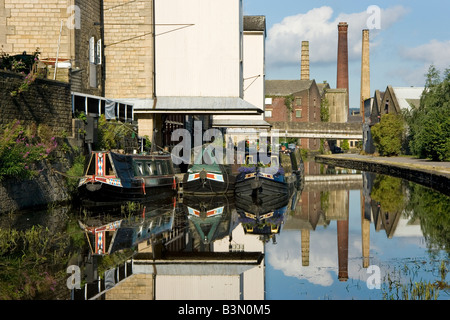 Usine chinmeys se reflètent dans le canal Leeds-Liverpool à Shipley, Bradford, West Yorkshire, Royaume-Uni Banque D'Images