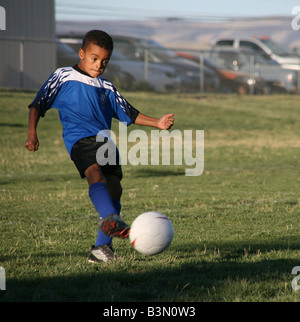 Garçon joueur de football kicks ball Banque D'Images