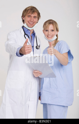 Jeune couple portant l'ensemble du médecin, donnant un coup de pouce Banque D'Images