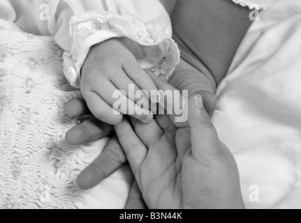 Les mains d'un nouveau-né petite fille et ses deux sœurs famille amour compassion Banque D'Images