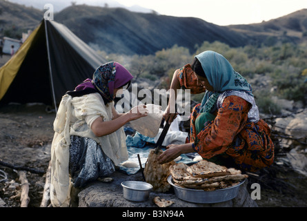 Deux femmes personnes transplantées de faire du pain dans un four en terre kurde traditionnelle. Ils vivent encore dans des tentes, BARZAN VALLEY PRÈS DE DIANA Banque D'Images