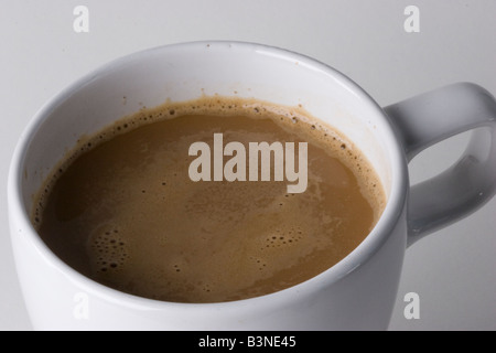 Café avec un peu de lait dans la tasse blanche avec fond blanc Banque D'Images