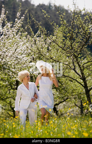 Allemagne, Baden-Württemberg, Tübingen, Mature mother and daughter walking through meadow Banque D'Images