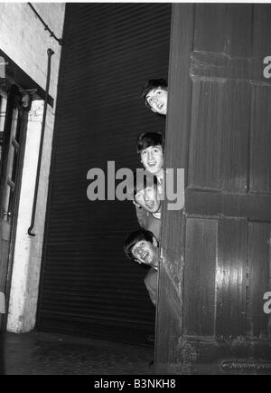 Peering Beatles de derrière une porte en 1963 Banque D'Images