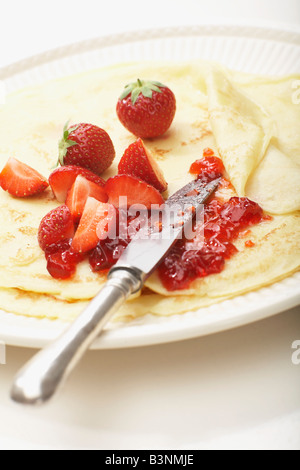 Crêpes avec de la confiture de fraise sur la plaque, close-up Banque D'Images