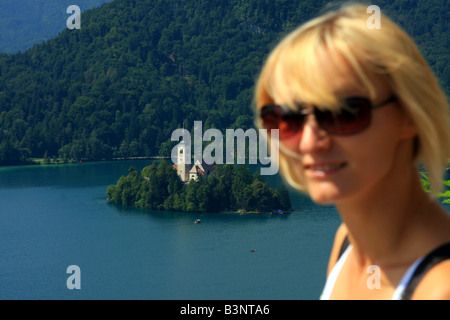 Belle vue sur le lac de Bled en Slovénie depuis le haut avec femme blonde à l'avant. Se concentrer sur l'île et l'église dans la zone Banque D'Images