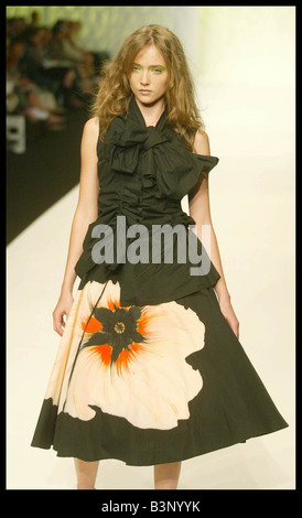 London fashion week Printemps Été 2003 Septembre 2004 John Rocha Vêtements Fashion catwalk show modèles une dentelle top noir avec une ligne d'une jupe noire avec une grande fleur blanche et orange imprimé sur la face avant Banque D'Images