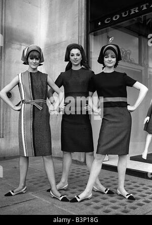 Fashions prises lors de la London Fashion Week 1964 Trois femmes portant des robes à rayures avec chapeaux de style foulard debout avec leurs mains sur leurs hanches à la provocation Banque D'Images