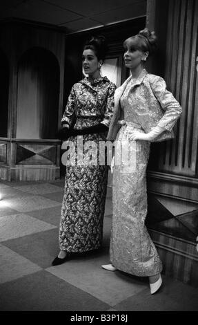 Fashions prises lors de la London Fashion Week 1964 portant des robes de soirée robe avec gants longs Banque D'Images