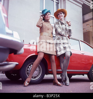 La mode des années 60 années 60 les vêtements des femmes avec chapeaux leaning on car Tweed fashions Mirrorpix Banque D'Images