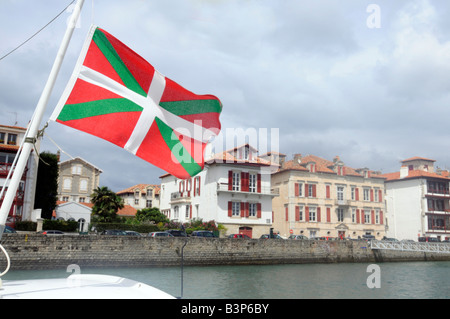 Un drapeau Basque à partir d'un mât du bateau dans le port de St Jean de Luz, une petite ville dans le Pays Basque, Sud Ouest de la France Banque D'Images