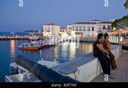 Les touristes assis sur un mur à New Harbour, Spetses, Grèce Banque D'Images