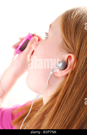 Jeune fille à l'écoute de la musique sur son lecteur mp3 fond blanc Banque D'Images