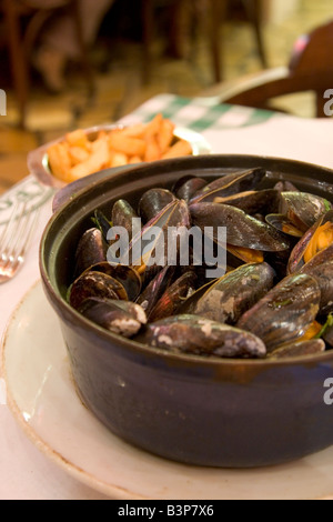 Spécialité locale de 'Moules' Frittes moules et frites dans un restaurant populaire 'Leon' à Bruxelles Belgique Banque D'Images