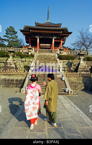 Le Japon, Kyoto, temple Kiyomizudera gate couple wearing kimono traditionnels exerçant son parasol Banque D'Images