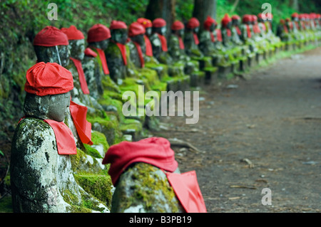 Le Japon, Honshu, la préfecture de Tochigi. Kanmangafuchi domaine de la ville de Nikko. Les statues de pierre Narabijizo porter du rouge. Banque D'Images