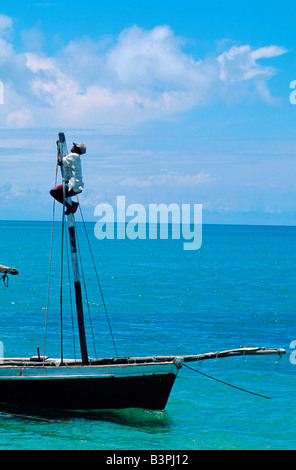 Le Mozambique, l'archipel de Bazaruto, Benguerra Island. Le pêcheur monte pour fixer la voile du mât de son bateau Banque D'Images