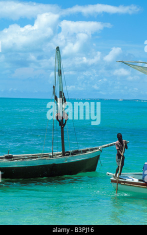 Le Mozambique, l'archipel de Bazaruto, Benguerra Island. Le pêcheur monte pour fixer la voile du mât de son bateau Banque D'Images