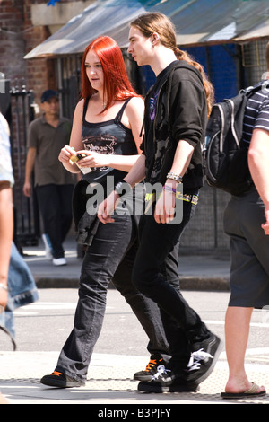 Marché de Camden Stables , jolie femme goth woman with red hair promenades avec homme garçon avec queue de cheval vêtue de jeans par la route Banque D'Images