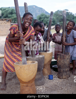 Le Malawi, Monkey Bay, centre du Malawi. Cheerful young girls livre le maïs à l'extérieur de leur domicile des familles près de Monkey Bay à l'extrémité sud du lac Malawi. La farine de maïs est la base de l'alimentation des Malawiens. Banque D'Images