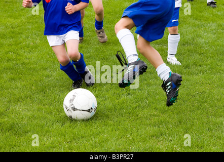 Close-up de joueurs se battent pour la balle dans un match de football pour les enfants Banque D'Images