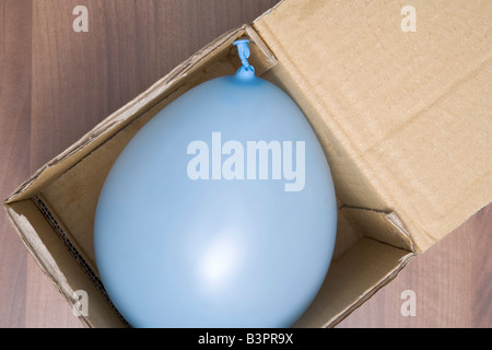 Ballon bleu-lumière dans une boîte en carton Banque D'Images