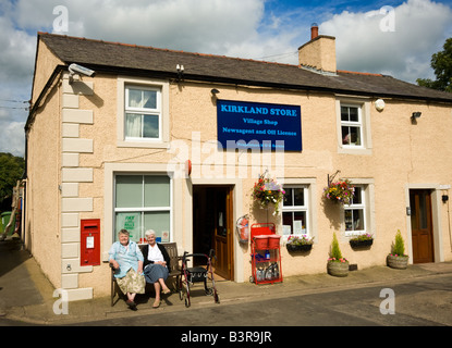 Corner shop, magasin du village et le bureau de poste de Caldbeck, Cumbria, Lake District, England, UK avec deux pensionnés le soleil brille à l'extérieur Banque D'Images