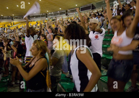 Les touristes locaux et encourager comme un but est marqué lors d'un match de football au stade Maracana à Rio entre Fluminense et Vasco. Banque D'Images