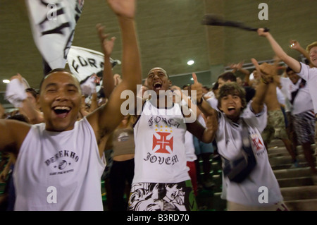 Les Brésiliens locaux cheer comme un but est marqué lors d'un match de football au stade Maracana à Rio entre Fluminense et Vasco. Banque D'Images