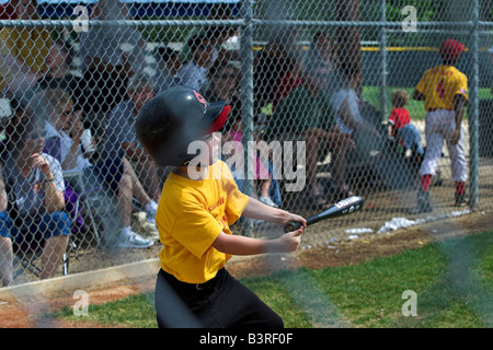 Un jeune homme se connecte avec l'entraîneur de baseball dans la petite ligue à pas variable. Banque D'Images