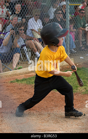 Un jeune homme se connecte avec l'entraîneur de baseball dans la petite ligue à pas variable. Banque D'Images