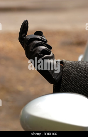 Une main gantée de cuir noir de l'automobiliste s'étend de la fenêtre les conducteurs de voiture Banque D'Images