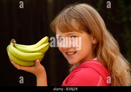 Main de bananes dans une main les jeunes filles Banque D'Images